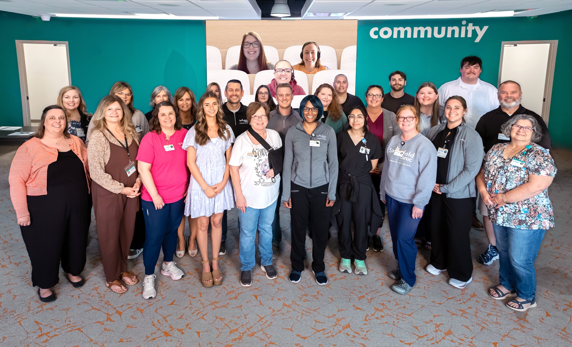 Springfield Clinic's Q1 2026 SC Celebrates Superstars gathered for a group photo in front of a teal wall reading “community.”